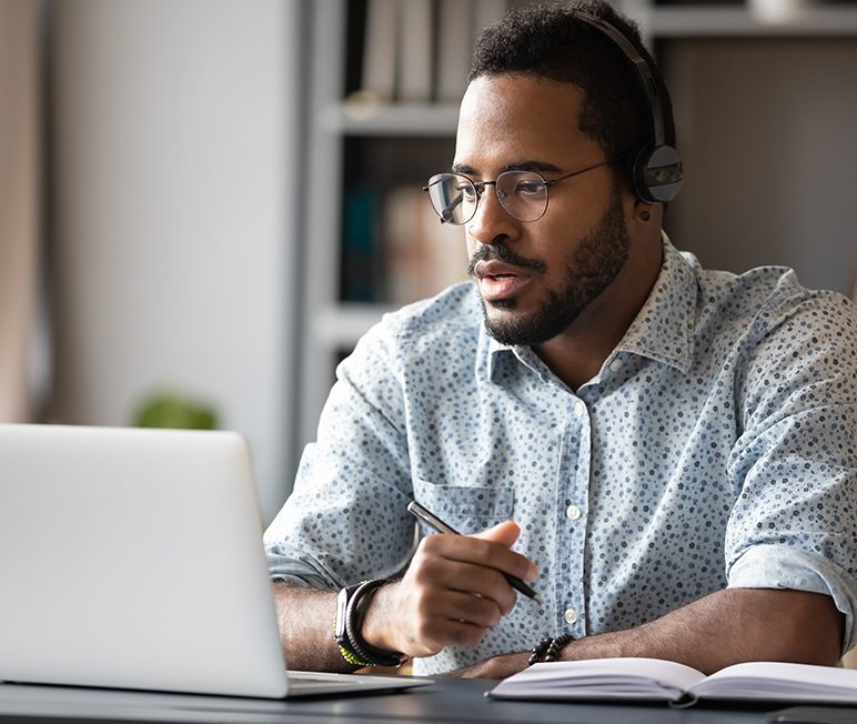 Focused african businessman wear headphones study online watching webinar Businessman